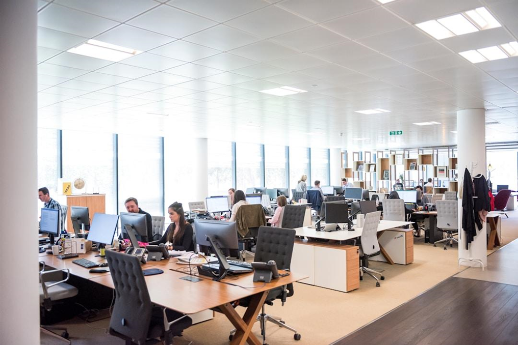 An office scene with employees focused on their desks, engaged in work related to AI deployment in customer service.